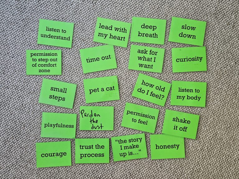 Green resource cards scattered on a carpet, each labeled with a coping tool or resource, such as 'deep breath,' 'pet a cat,' and 'trust the process.